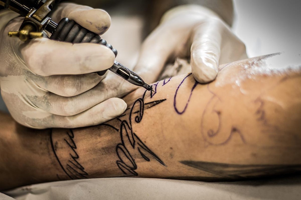 Vai fazer uma tatuagem nova? Você precisa saber dos cuidados essenciais 1 tatuador com cuidados essenciais para fazer uma tatuagem
